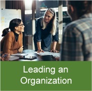 Click on this picture of three people around a table to access the leading an organization information.